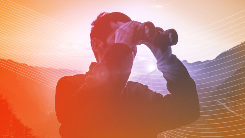 Man looking into distance with binoculars