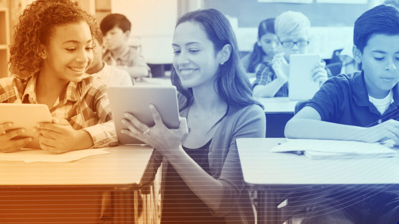 photo of teacher showing student how to use educational software on a tablet